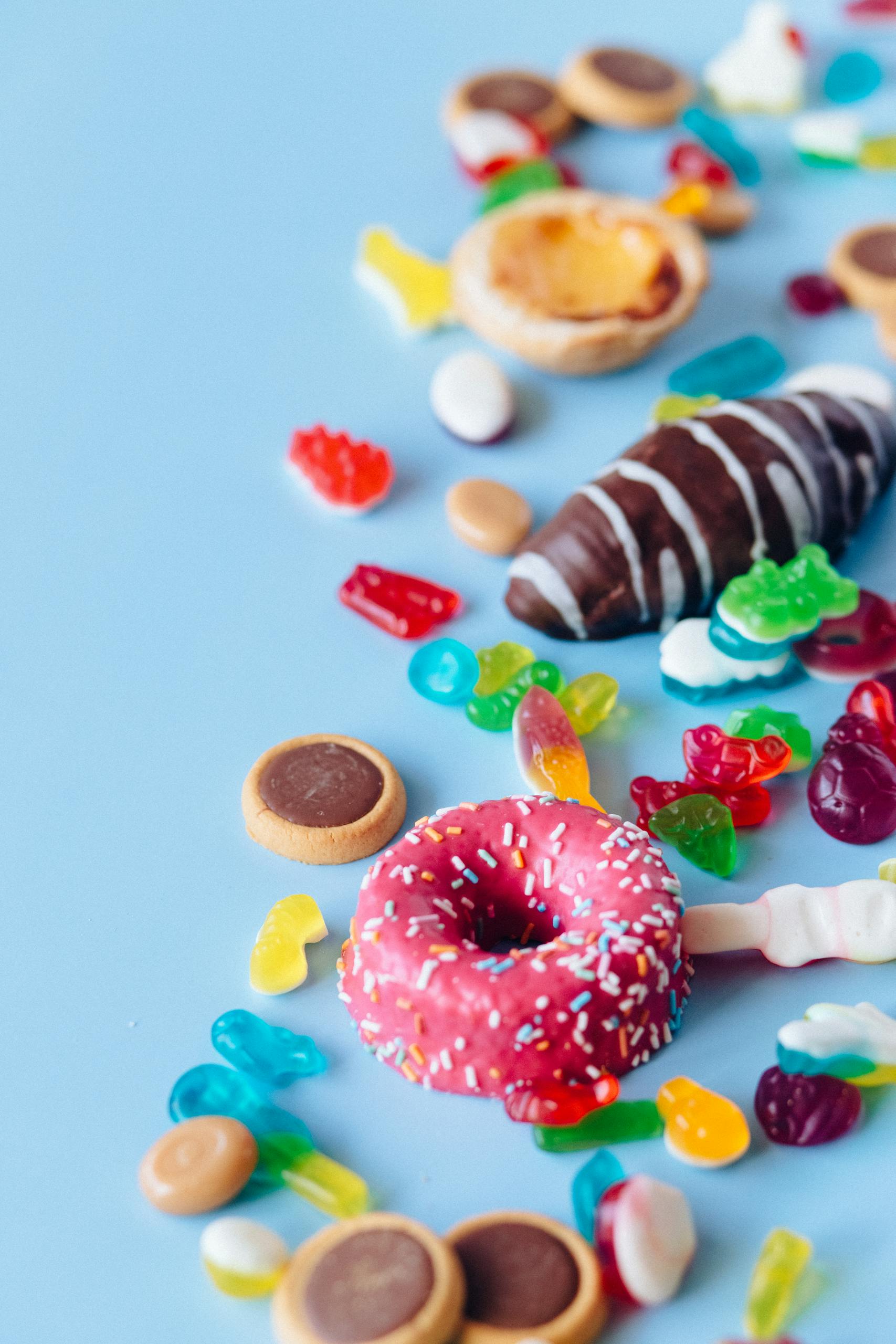A vibrant display of assorted candies and donuts on a blue background, perfect for sweets and snack themes.
